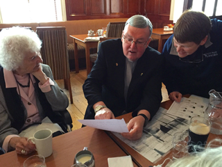 Father Martin Downey shows indenture papers to Molly as Roberta looks on